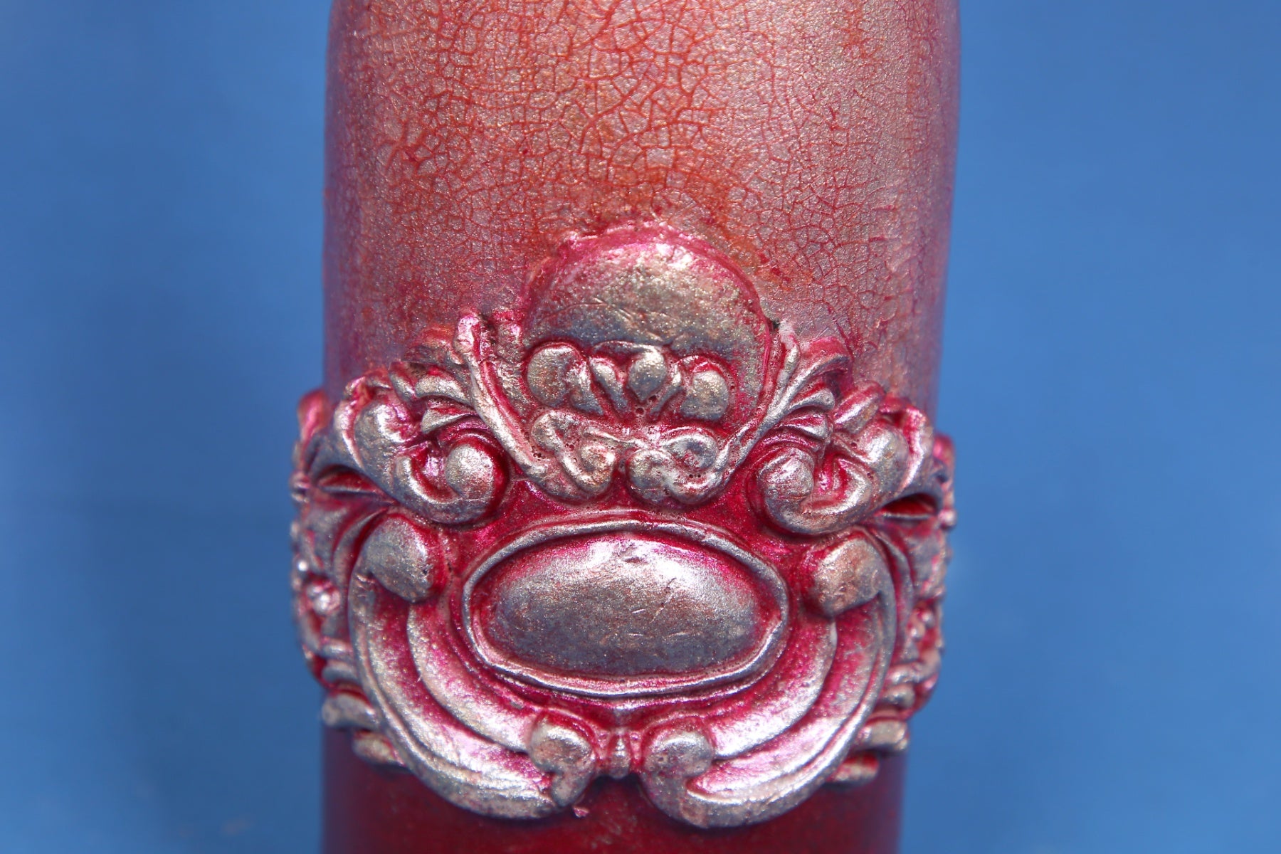Decorated wine bottle with pink cracks and baroque ornaments