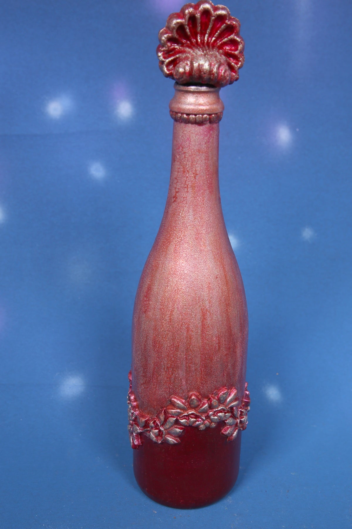 Decorated wine bottle with pink cracks and baroque ornaments